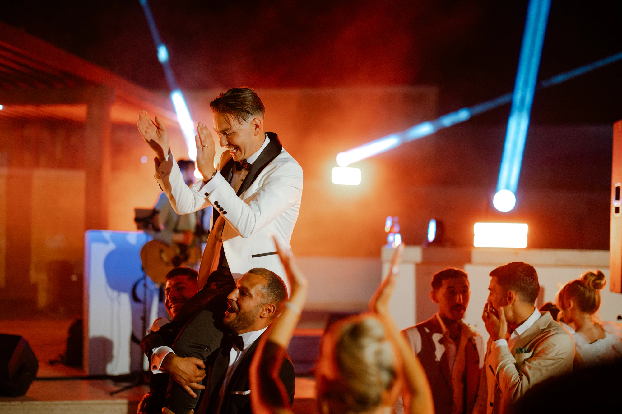 Gli amici lanciano in aria lo sposo durante la festa di matrimonio