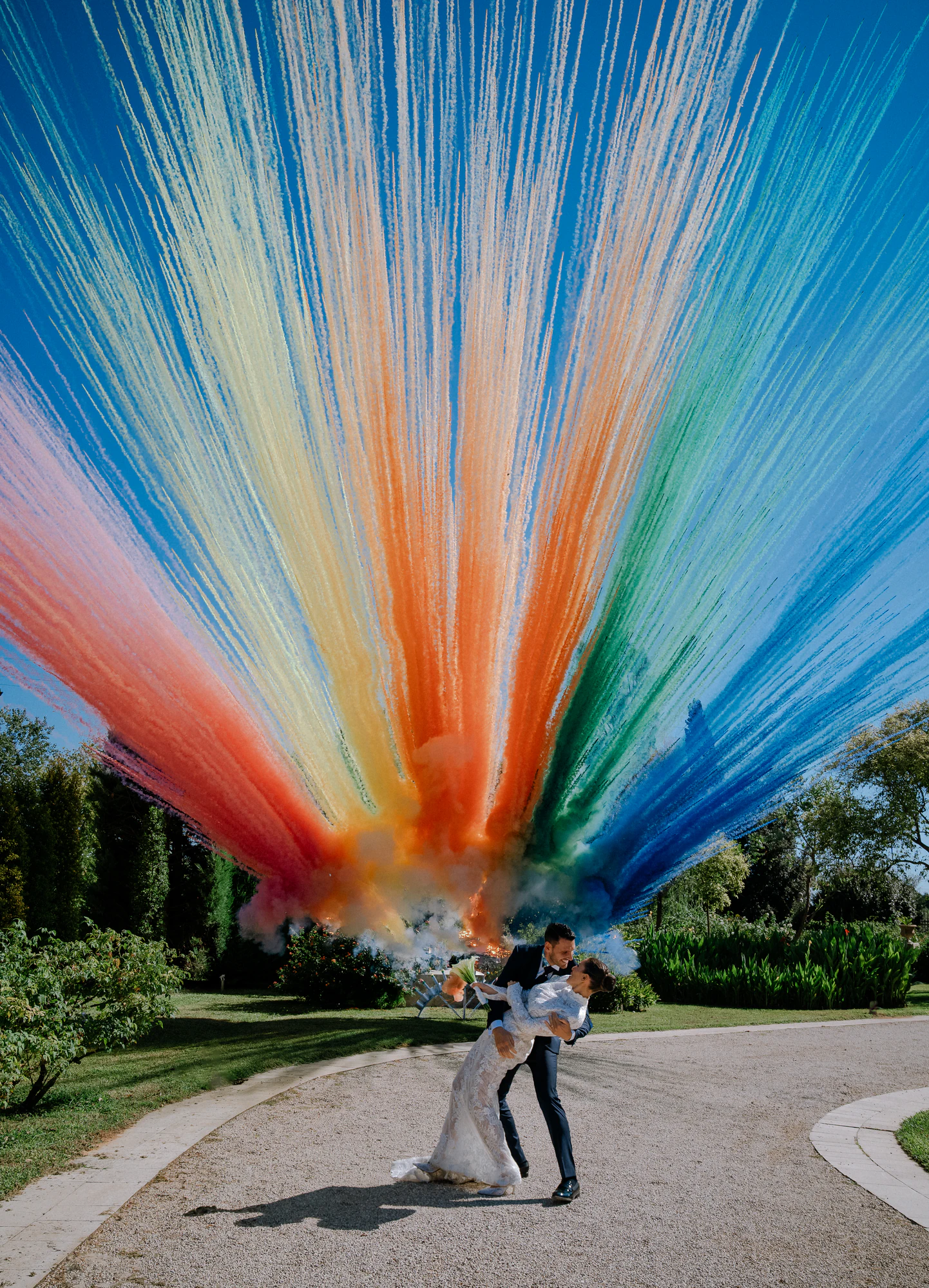 Casquè sotto una smoke bomb arcobaleno su cielo azzurro