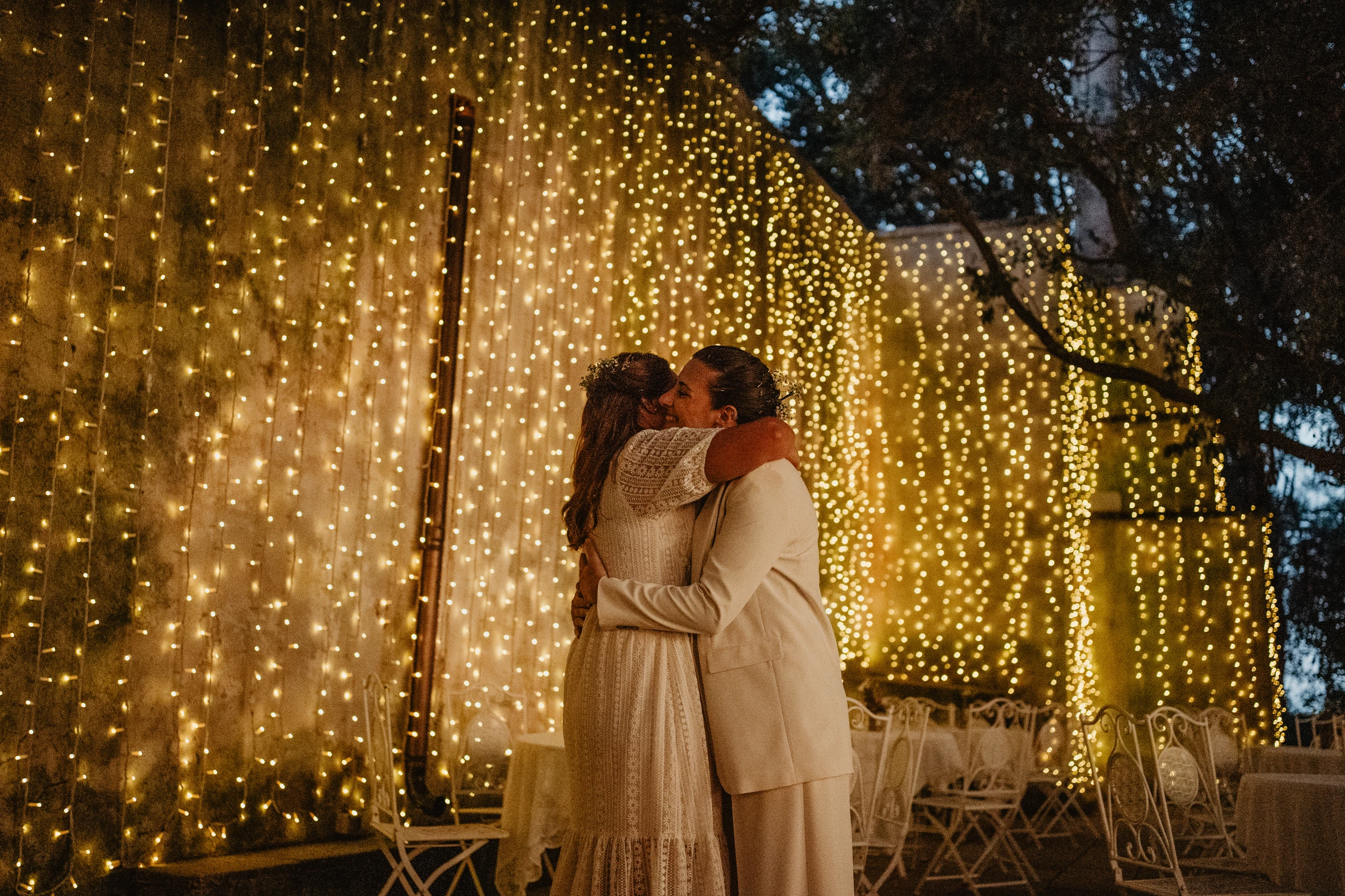 Emanuela Venuti fotografo matrimonio - abbraccio degli sposi tra le luci fatate